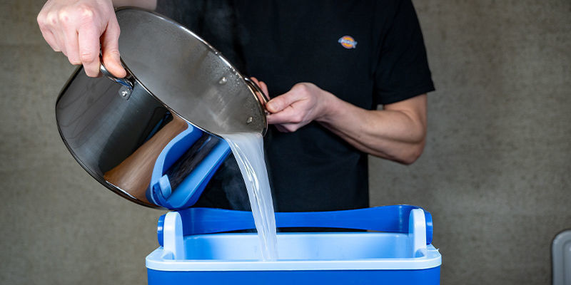 Una volta fatta bollire l'acqua ed aggiunto il gesso, versa la miscela sulla fibra di cocco e sulla vermiculite nel secchio