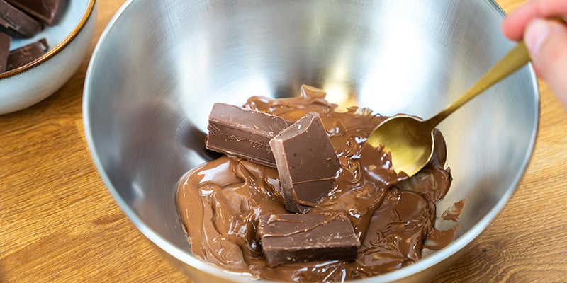 Spezzetta il cioccolato Quando il cioccolato si sarà sciolto, toglilo dal fuoco e aggiungi un altro quarto