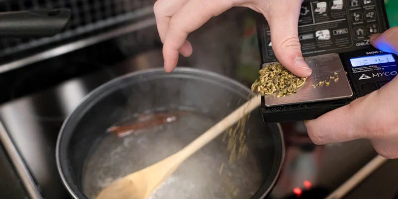 Aggiungi la cannabis decarbossilata nella pentola e fai sobbollire a fuoco basso per 20 minuti, mescolando di tanto in tanto.